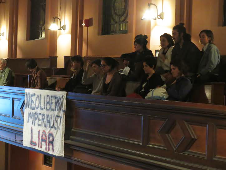 Students protest Jeffrey Sachs at Wednesday’s convocation. Protesters entered Finney Chapel during Sachs’s talk to speak out against his actions and the College’s decision to fund a speaker the protesters called a “neoliberalist capitalist.”