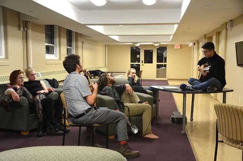 A small audience gathers to hear a student play guitar as part of a weekly open mic in Burton Hall basement. Conservatory first-year Garrick Olsen hosts the informal concert series every Thursday.