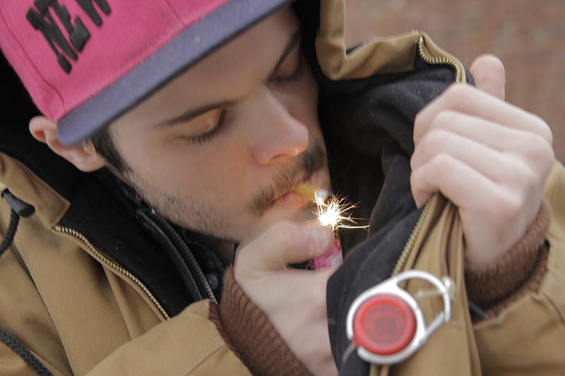 College junior Nick Canavan lights a cigarette. The College finalized the smoking ban last December, and the use of tobacco products on campus will be prohibited starting in the fall of 2016.