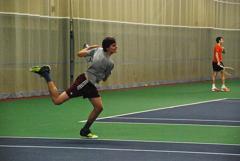 Junior Callan Louis follows through on a shot in a match against the Indiana Tech University Warriors on Friday, Feb. 27. The men’s tennis team has won four matches in a row heading into a showdown this Saturday at home against the John Carroll University Blue Streaks.