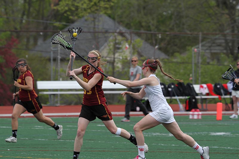 Junior Grace Barlow battles past a defender from the Wittenberg University Tigers last Wednesday in Springfield, Ohio. Barlow led the Yeowomen past the Tigers with four goals and two assists in a 13–9 win to advance Oberlin to the North Coast Athletic Conference Finals for the first time since 2000.