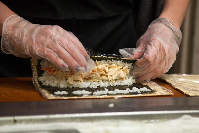 An employee makes a roll at Dascomb Dining Hall’s sushi bar. Many international students have cited Campus Dining Services’ cuisine as culturally
￼appropriative.