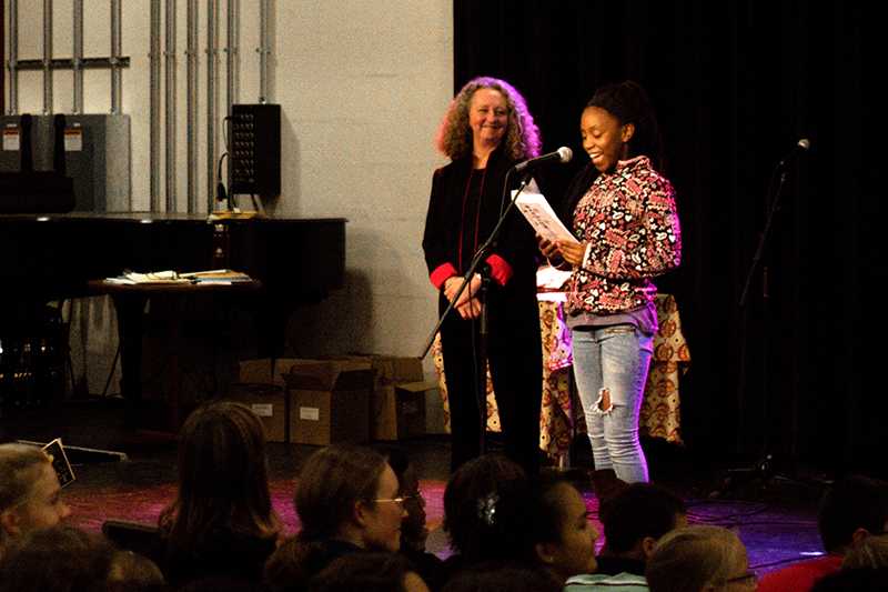 Sixth-grader Tnadja Williams reads her poem “Grandmother” from Eileen Hickerson’s and Nicholas Sakola’s class anthology, “Put Your Attitude into Space,” at the Cat in the Cream. The event featured Langston Middle School students reading poems written in classes led by Writers-in-the-Schools Director Lynn Powell and
College students in the Teaching Imaginative Writing workshop.