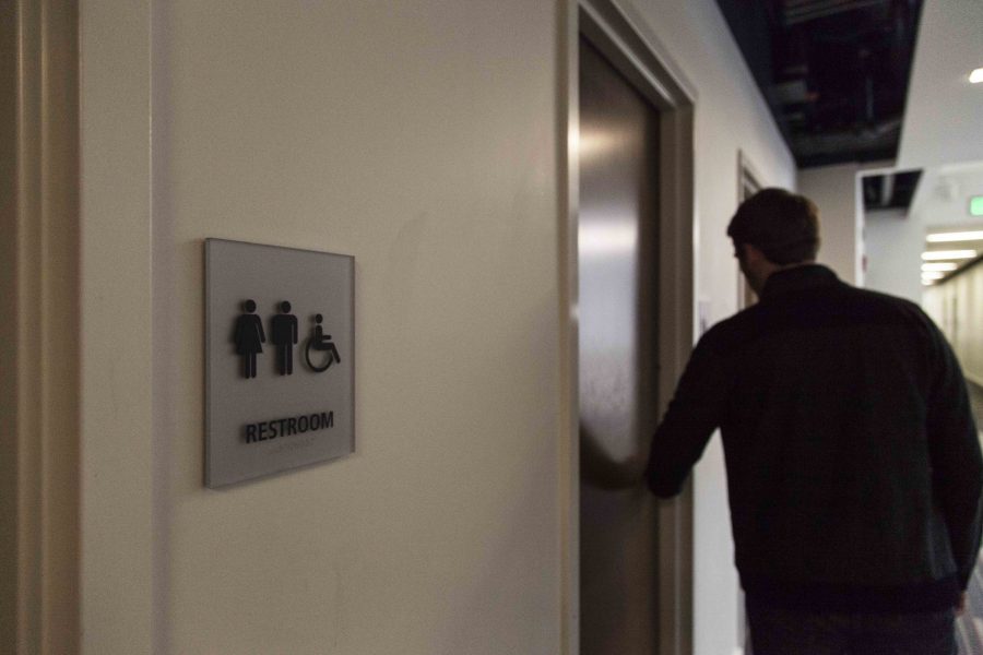 A student walks into a bathroom in the Science Center. Students have recently questioned the lack of gender-neutral restrooms in academic buildings.