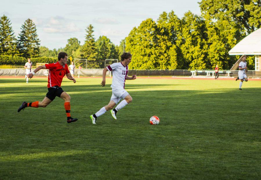 Junior forward Tim Williams dribbles away from a Heidelberg University defender. Oberlin defeated Heidelberg 3–1 in its season opener. The Yeomen now hold a 1–1 record. 