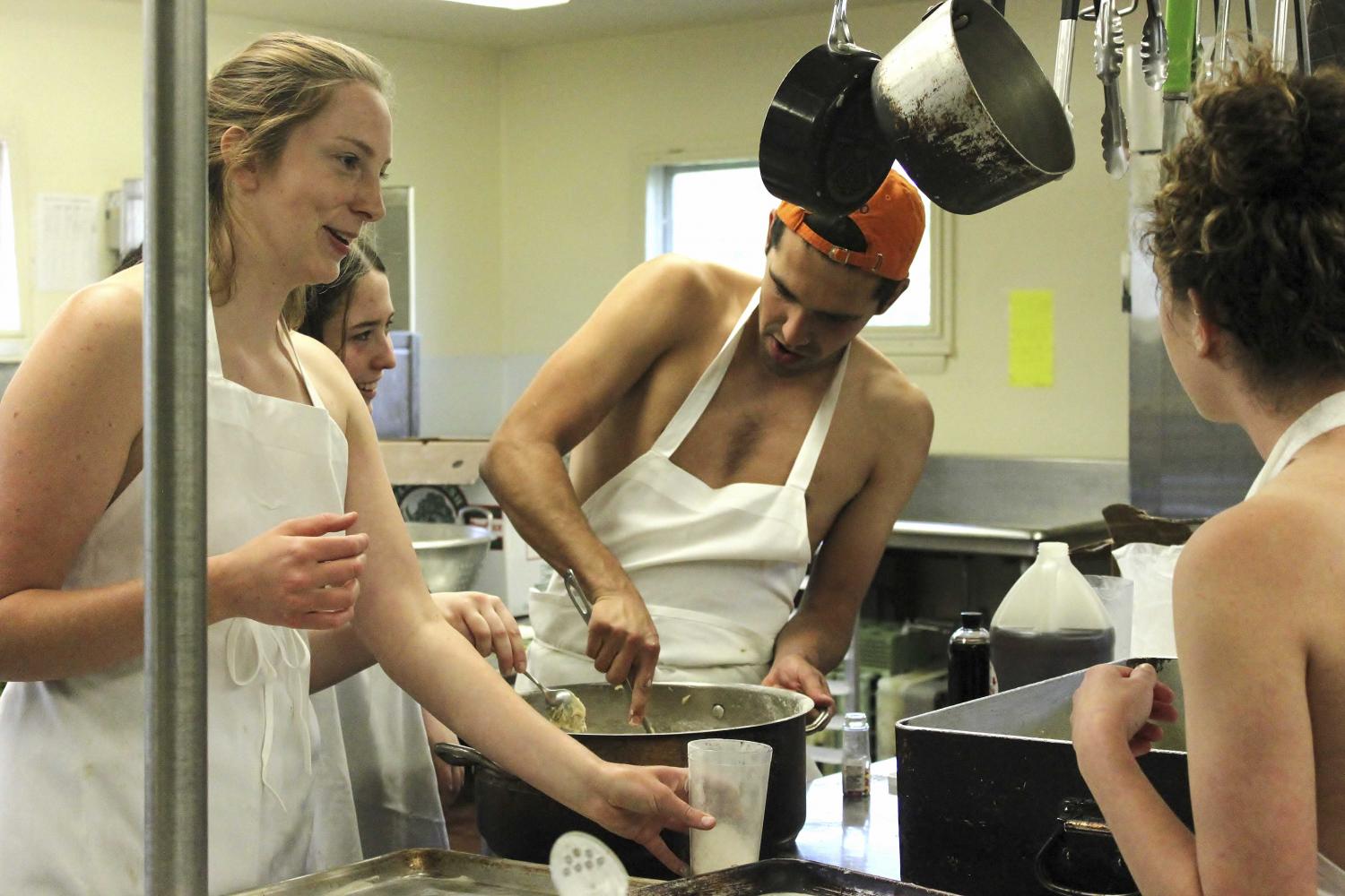 Left to right: College sophomores Juna Keehn and Leora Swerdlow, College junior Luke Fortney and College senior Beth Minahan cook topless at Old Barrows co-op. The co-op’s kitchen will close this semester and the building will undergo renovations this summer.