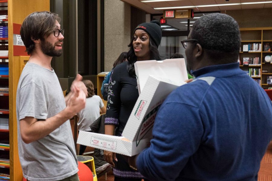 College senior Paddy McCabe discusses a survey he took on his desired campus improvements with Student Senate Vice Chair Kameron Dunbar and President Carmen Ambar. Students who participated received a free Krispy Kreme donut.