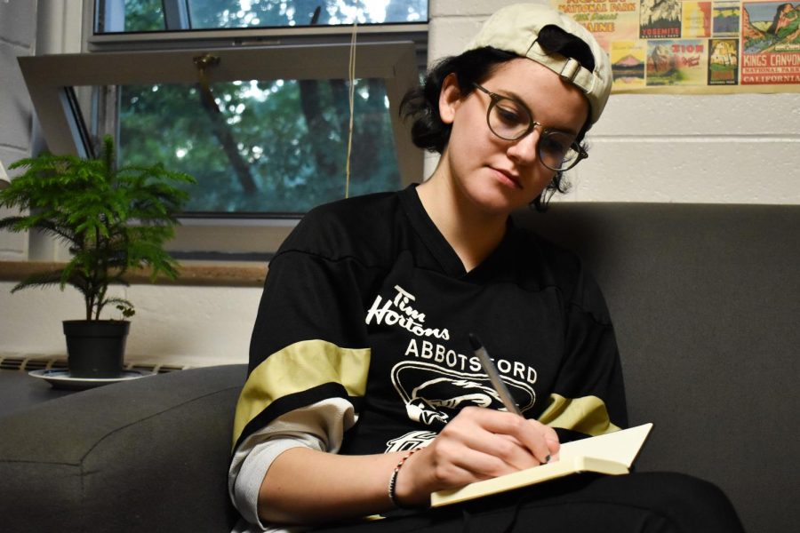 Conservatory senior Zoe Heuser writes in her diary. She is one of the many students who read their inner thoughts aloud during last Friday’s Diary Reading Open Mic at the Cat in the Cream.