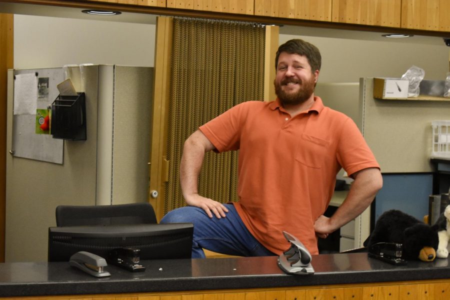 Joseph B. Maiville, OC ’07, poses behind the circulation desk in Mudd library.