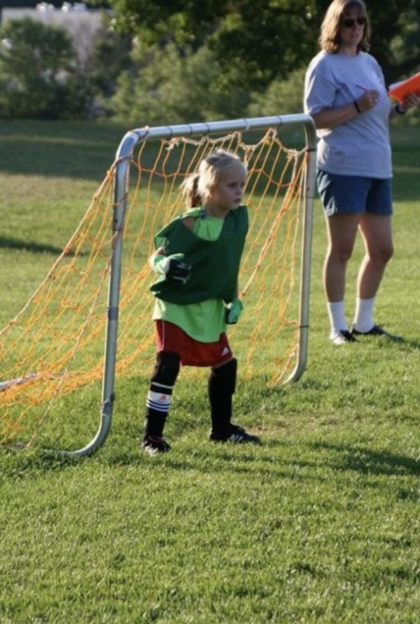 Young Belle Smith stands in a goal.