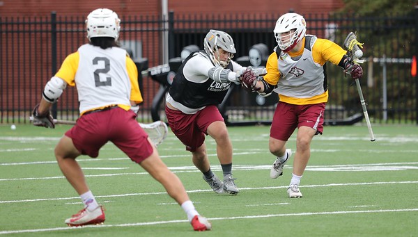 College fourth-year and men’s lacrosse player JT Starcke on Bailey Field cradling the ball up the field.