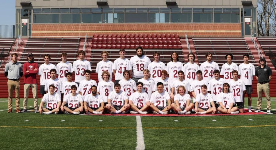 Men%E2%80%99s+lacrosse+2021%E2%80%9322+team+and+coaching+staff+stand+on+Bailey+Field.