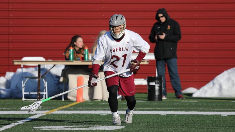 Long stick midfielder and defender Matthew Huang runs on Bailey Field all geared up for a home game.