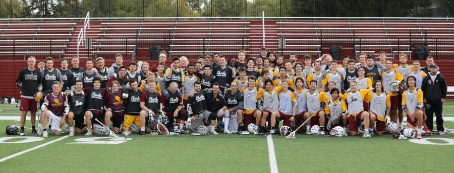 Current and former mens lacrosse players pose for a photo. 