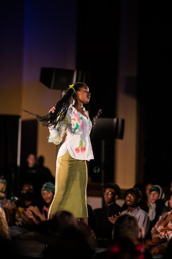 Models posed in fashion show wearing designs crafted by students using sustainable clothing and resources.