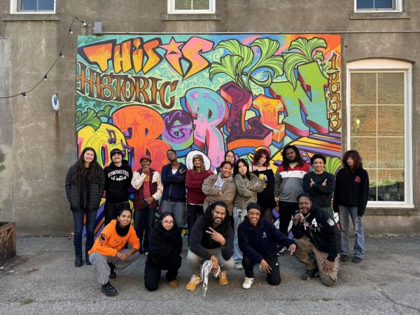 Michael Roman’s Intro Aesthetics of Hip Hop: Graffiti from Boxcar to Basel class poses in front of its graffiti mural.