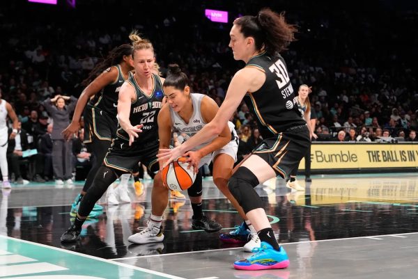 Las Vegas Aces guard Kelsey Plum dribbles into traffic against the New York Liberty.