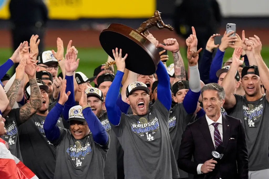 The Los Angeles Dodgers celebrate their World Series victory, holding up the trophy after defeating the New York Yankees in five games.